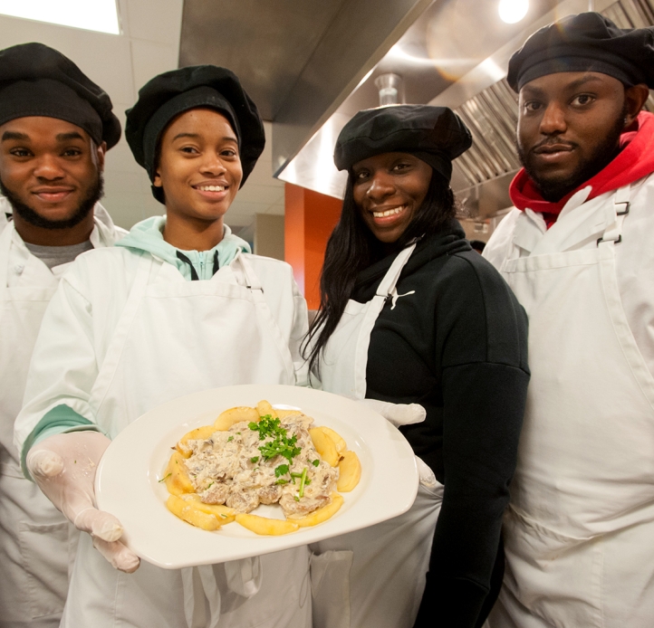Four students holding a plate of food