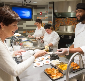 Students serving food in the demonstration kitchen