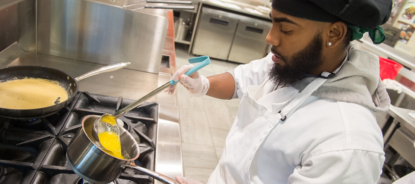 Student preparing a sauce